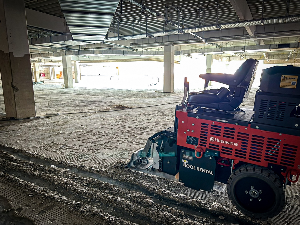 Aufsitz- Akku Bodenbelagentferner auf einer Baustelle